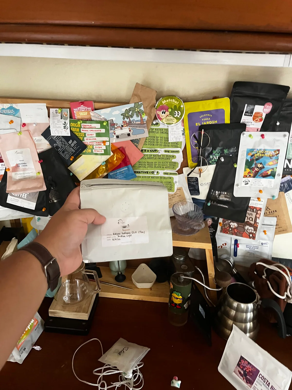 Coffee bags and brew notes pinned above the home coffee station